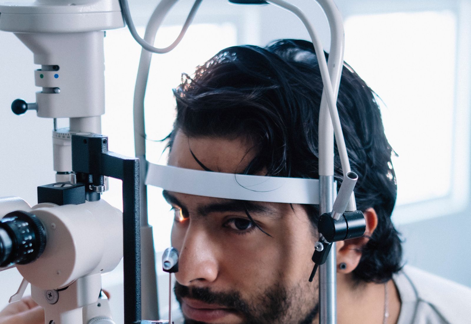 Patient seated at a slit lamp with chin and forehead resting in place